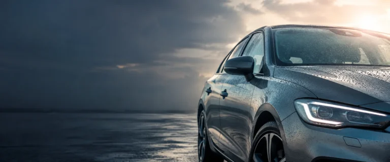 Sunlight and rain beads on a car's paint, glazing and exterior trim